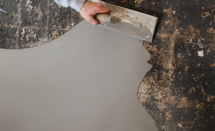 A person using a leveling tool on a tile floor.